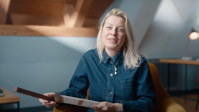 Rachel Clark BSC sat in a chair holding a clapperboard