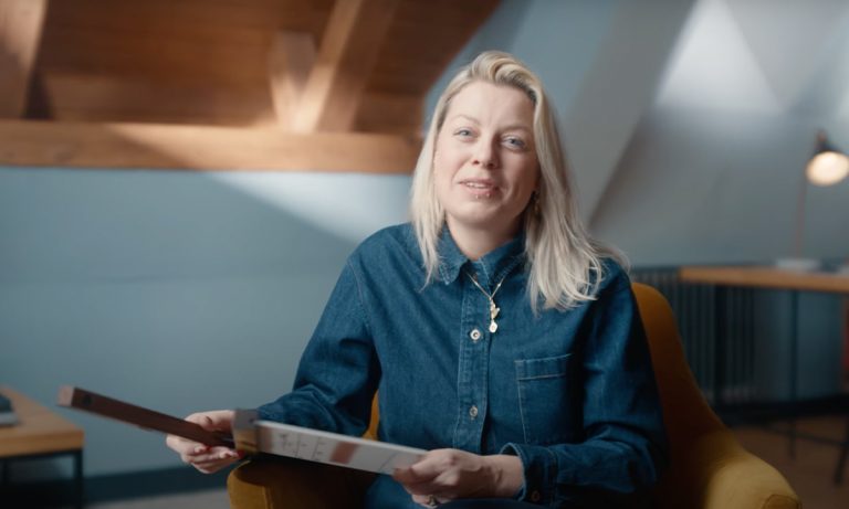 Rachel Clark BSC sat in a chair holding a clapperboard