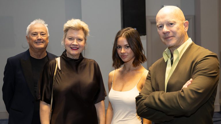 Four people stood together smiling