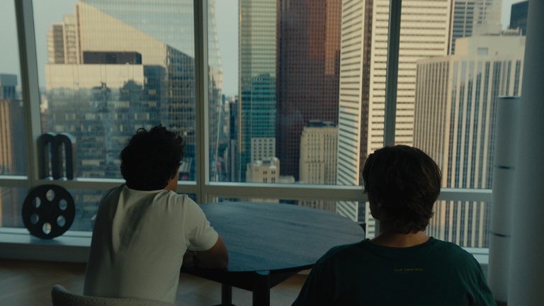 Two men sat looking out over a city