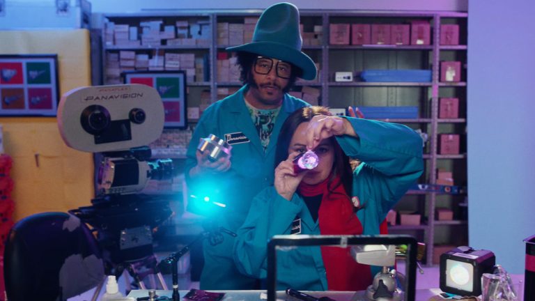 Two people in a film lab looking into camera
