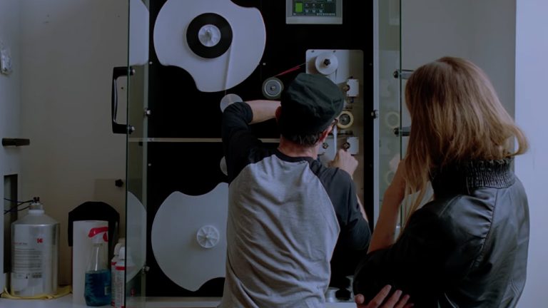 Two people looking at film reels