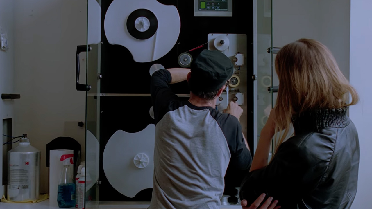 Two people looking at film reels