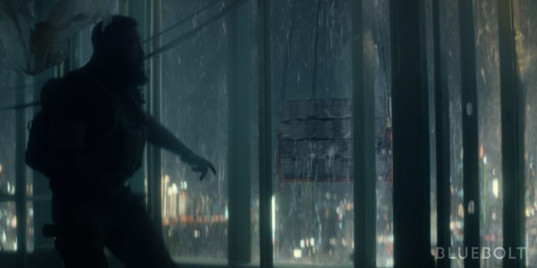 A man in fight gear against a rainy backdrop