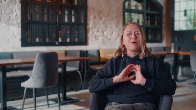 A woman sat talking to camera