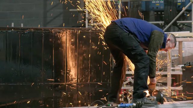 A man using a tool with sparks flying off