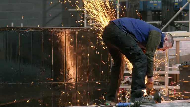 A man using a tool with sparks flying off