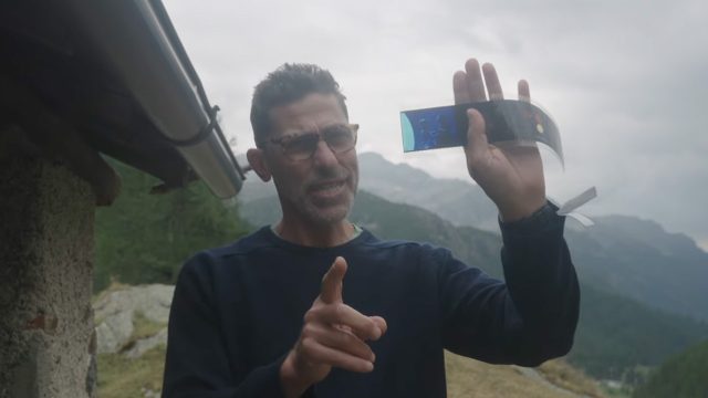 Ed Sayers holding a piece of film and pointing at camera