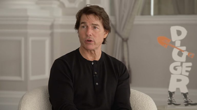 Tom Cruise sat in a black t-shirt